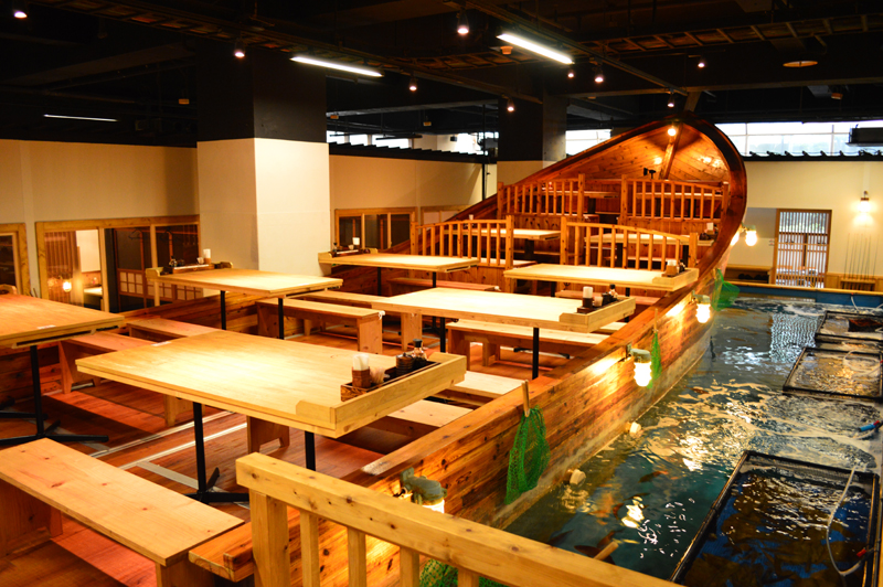 釣船の周りをさまざまな魚が泳ぎ回るいけすがこのお店の最大の特徴