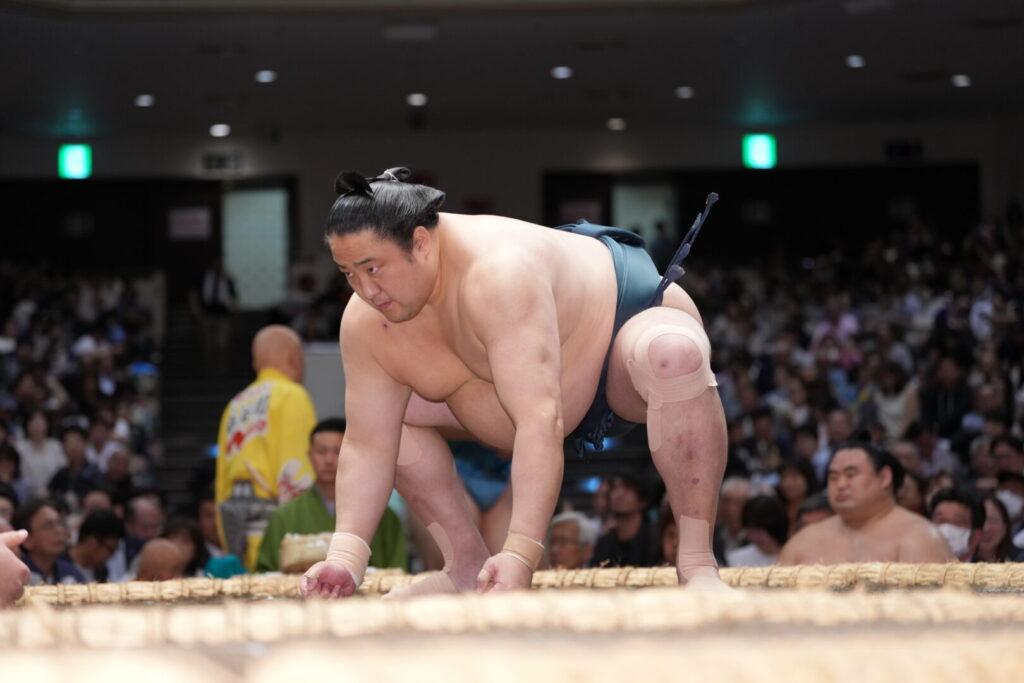 仕切りの瞬間。腰を落として両手を土俵につく
